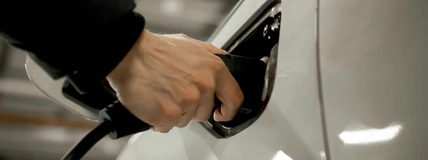 Hand tankt Fahrzeug mit Strom