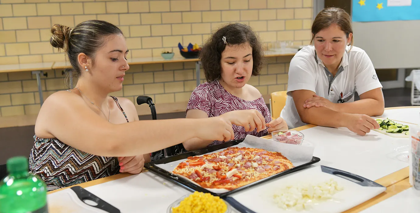 Jugendliche am Pizza vorbereiten für das Essen bei den Jugendrehawochen im Schweizer Paraplegiker-Zentrum