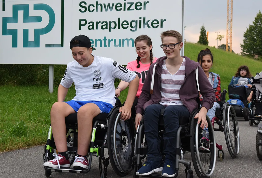 Jugendliche im Rollstuhl vor dem SPZ-Schild