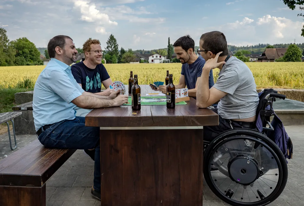 Mathias Studer mit seinen Freunden an einem Tisch am jassen