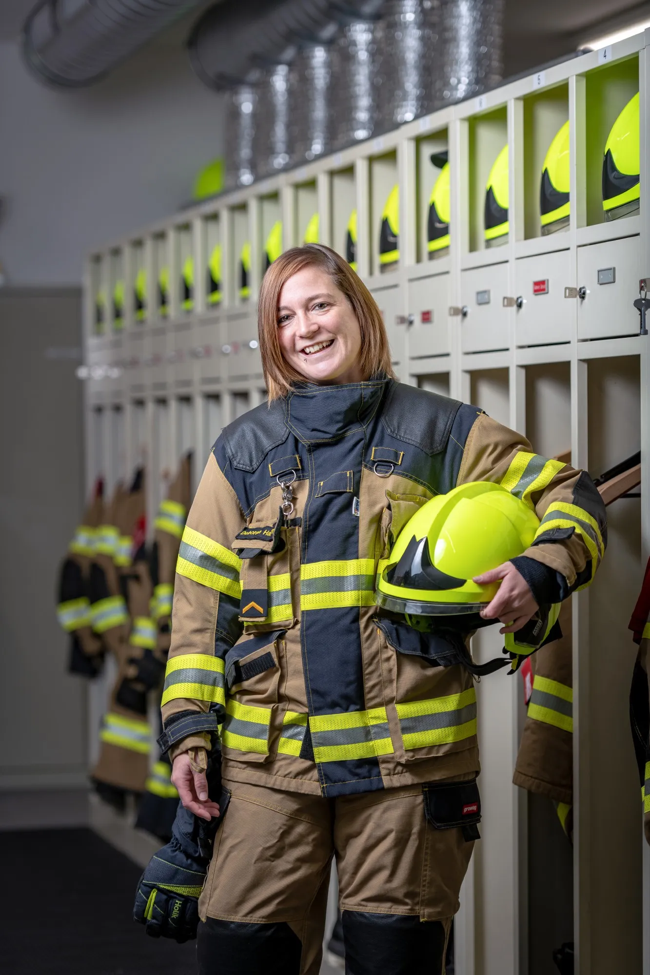 Eine Mitarbeiterin der Feuerwehr ist in ihrer Berufskleidung abgebildet.