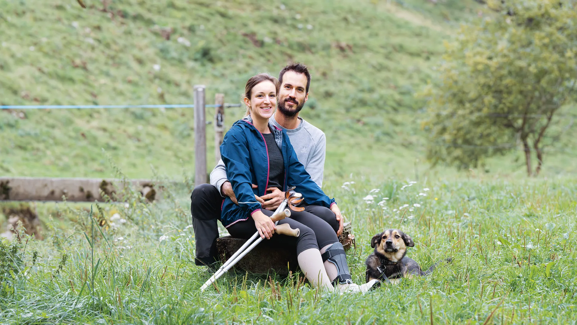 Andrea Treier und ihr Partner Andreas Signer sitzen auf einer Wiese.