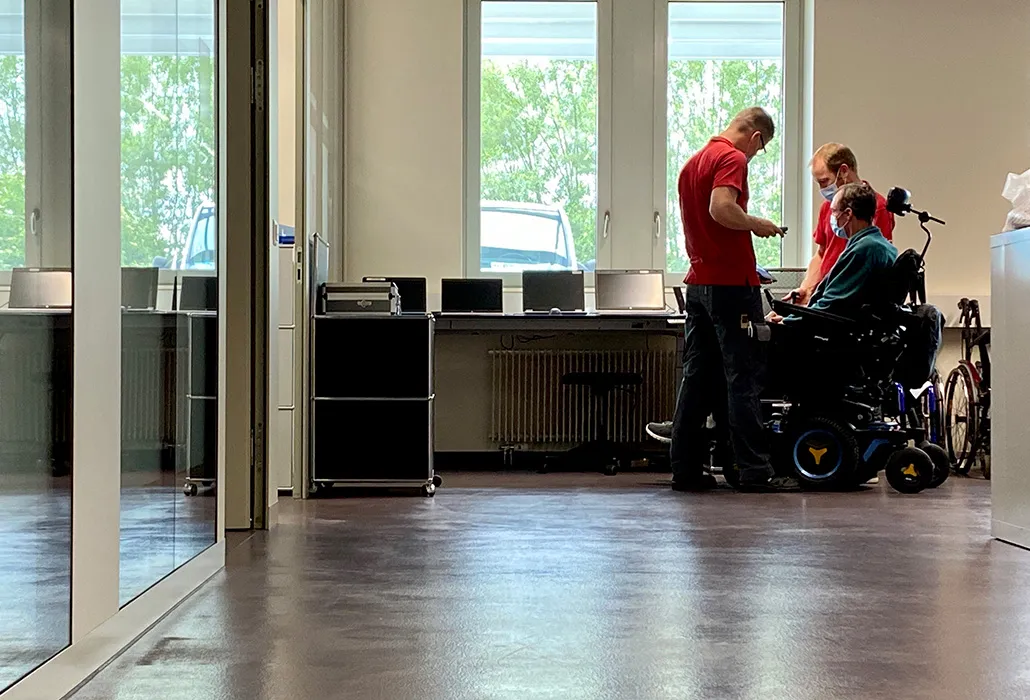 Die Einstellungen des Elektrorollstuhls werden optimiert. 