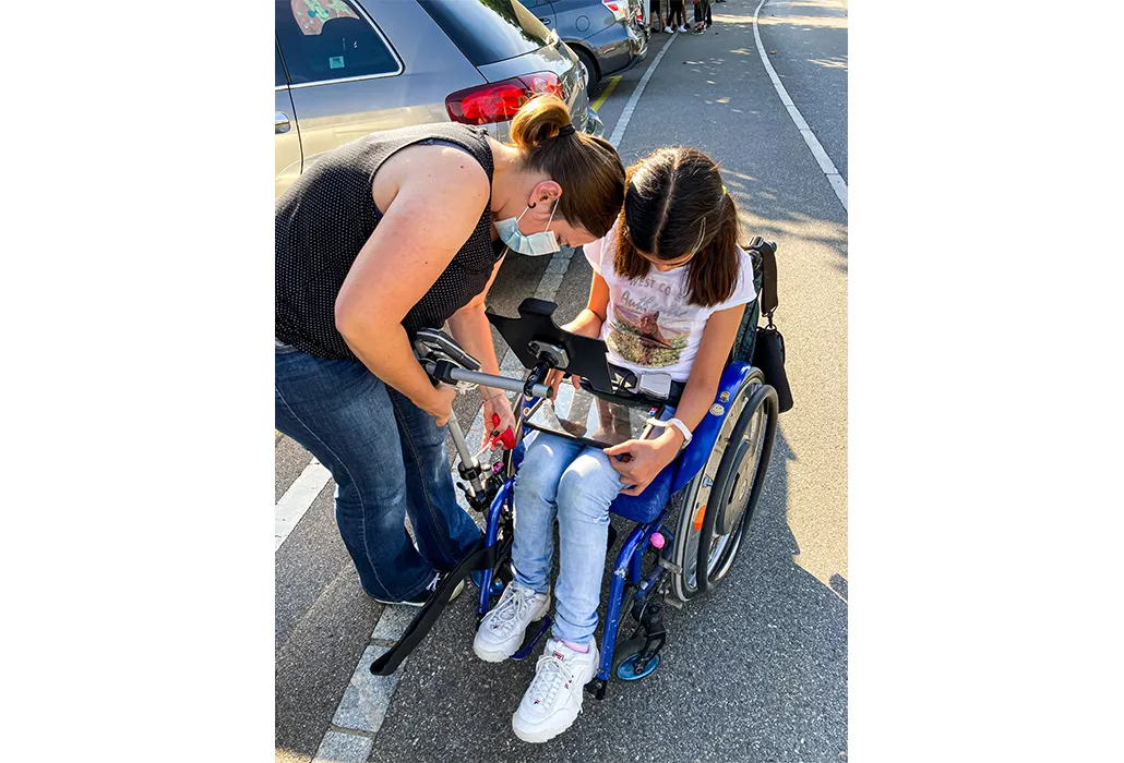Die Beraterin holt Werkzeug aus dem Auto und repariert wie besprochen Lea’s iPad-Halterung.